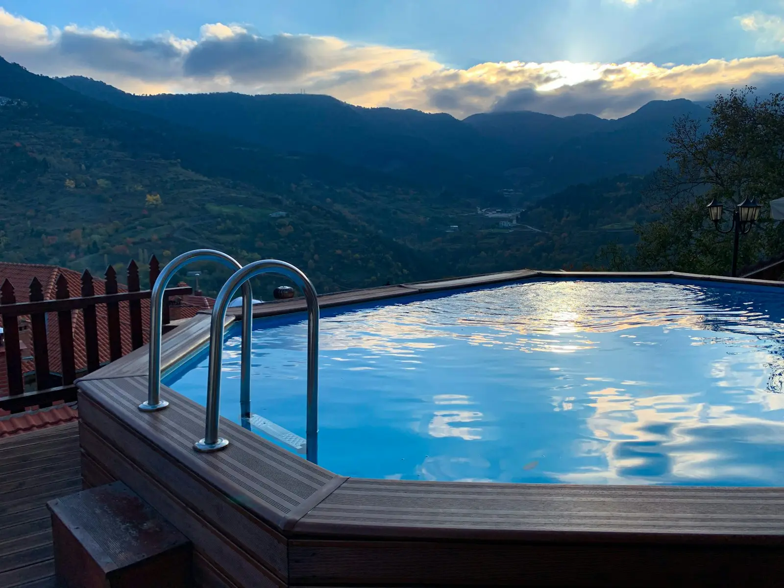 Piscine bordée d'une terrasse en bois, avec vue plongeante sur une vallée de montagne